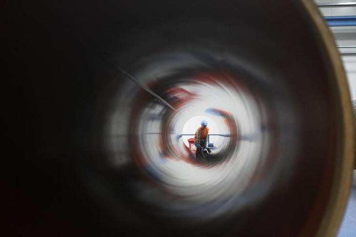 © Reuters. A worker is seen through a pipe at French pipe coating company EUPEC in Sassnitz