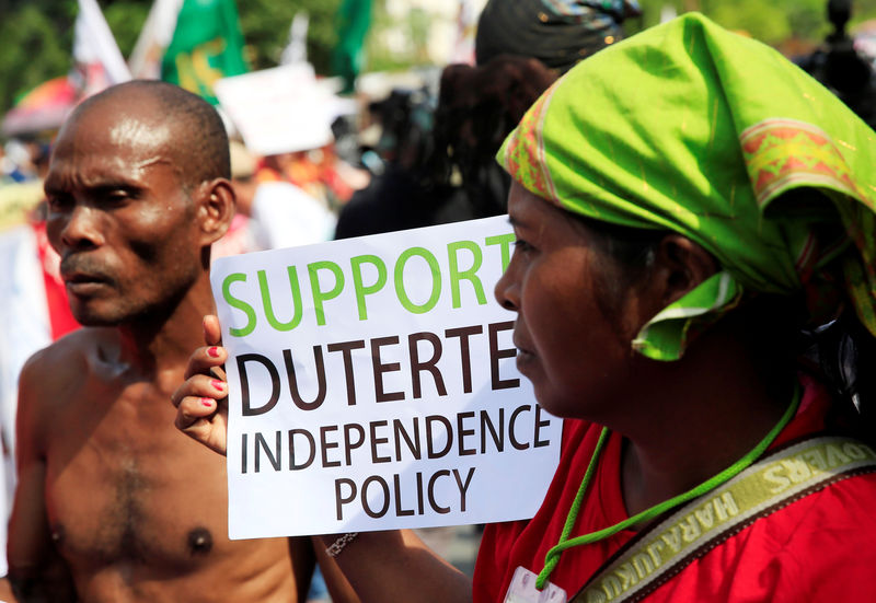 © Reuters. An Indigenous person holds a placard as she joins a rally supporting President Rodrigo Duterte's independent foreign policy in metro Manila