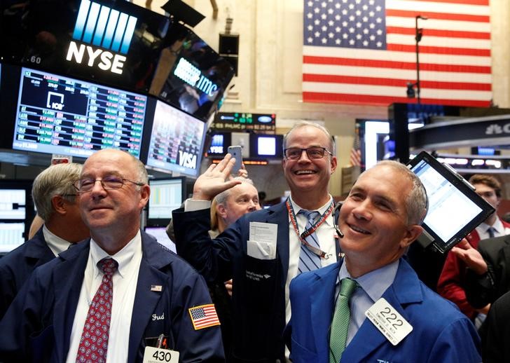 © Reuters. Traders react while working on the floor of the NYSE