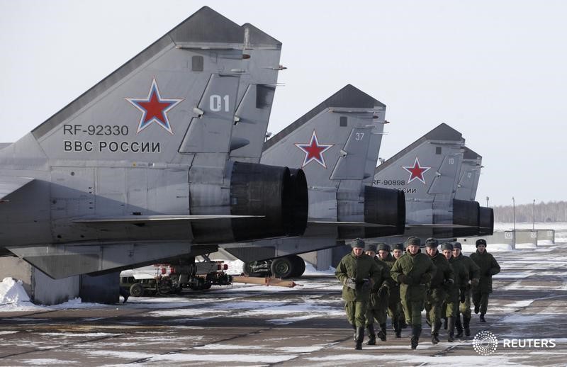 © Reuters. Военнослужащие российской армии у сверхзвуковых МиГ-31Б в Канске