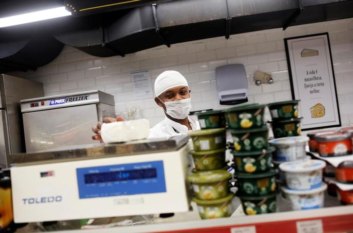 © Reuters. Funcionário pesa um pedaço de queijo em mercado no Rio de Janeiro, Brasil