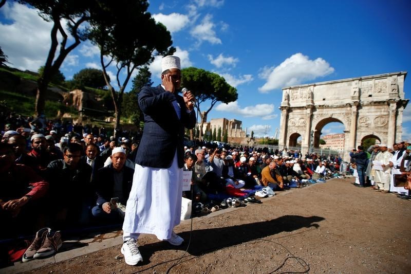 © Reuters. مسلمون يؤدون صلاة الجمعة أمام الكولوسيوم احتجاجا على إغلاق مساجد في روما