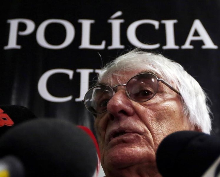 © Reuters. Formula One chief Ecclestone talks to the media in police central station in Sao Paulo