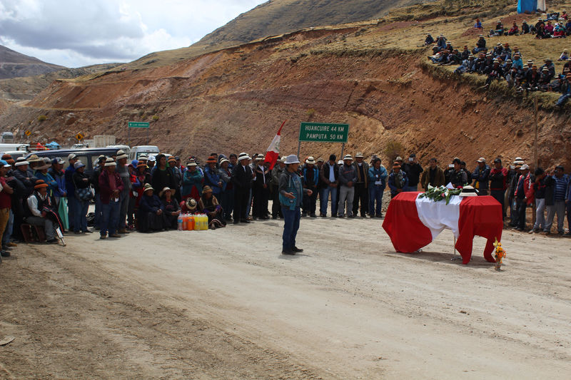 © Reuters. Protesters block a road standing next to the body of Quintino Cereceda Huisa in Apurimac