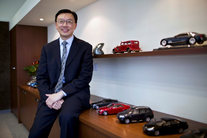 © Reuters. Tsien, president of GM China, poses for a photograph next to GM car scale models in his office at the company's headquarters in Shanghai