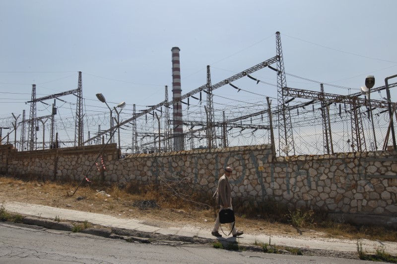 © Reuters. A man walks outside a Public Power Corporation's (PPC) electric power station at Keratsini suburb near Athens