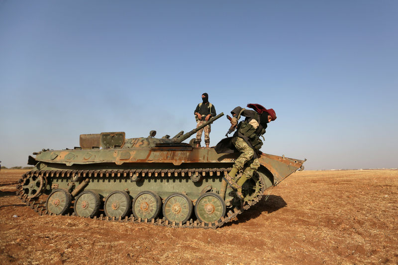 © Reuters. A rebel fighter jumps from a military vehicle on the outskirts of Syria Democratic Forces (SDF) controlled Tell Rifaat town, northern Aleppo province