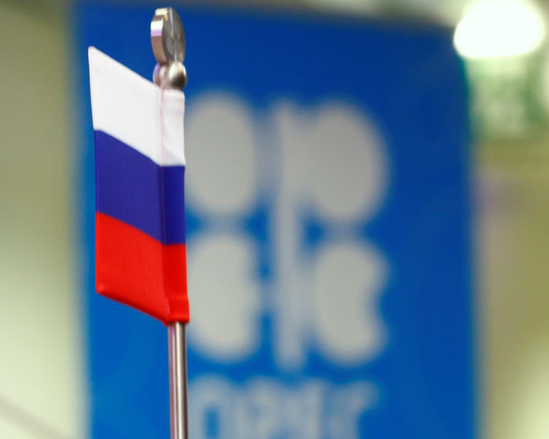 © Reuters. The Russian flag and the OPEC logo are seen before a news conference in Vienna