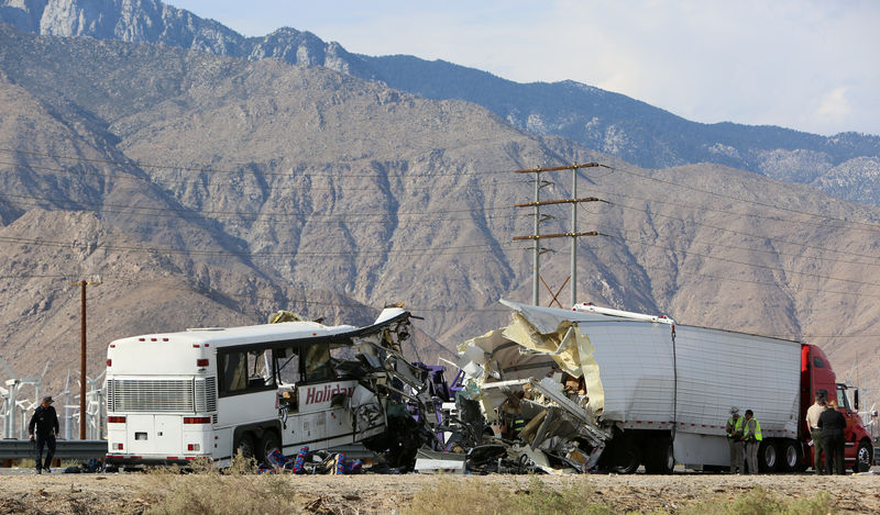 © Reuters. Investigators confer at the scene of a mass casualty bus crash on the westbound Interstate 10 freeway near Palm Springs