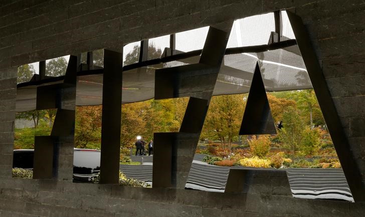 © Reuters. A TV team is reflected in a logo of FIFA at its headquarters in Zurich