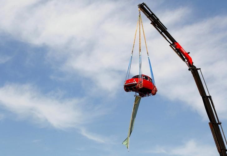 © Reuters. A vintage Fiat 500 Cinquecento car is lifted by crane during meeting of Fiat 500 clubs in the central Swiss town of Zug