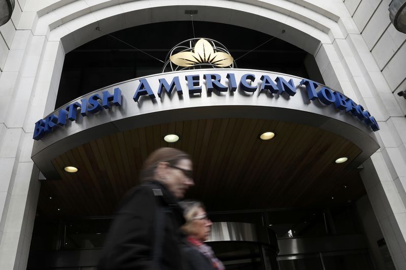 © Reuters. People walk past the British American Tobacco offices in London