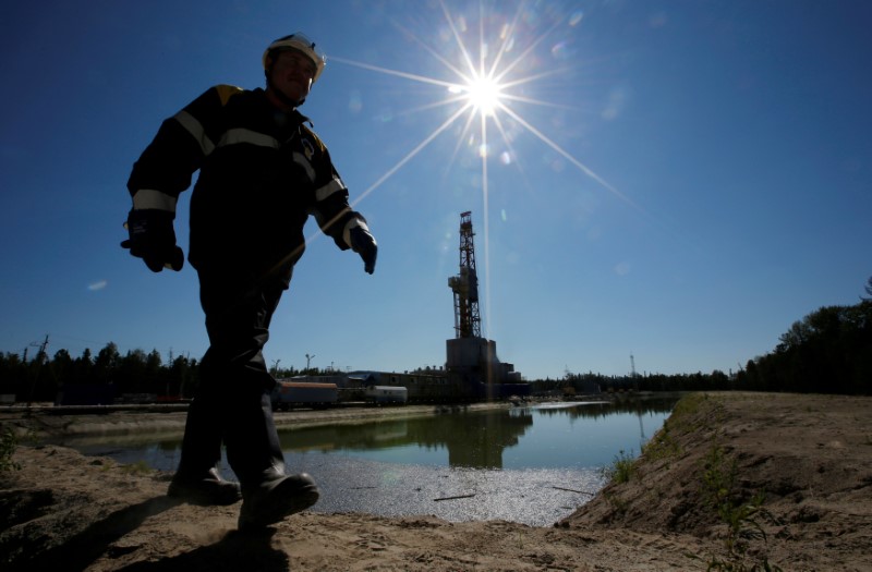 © Reuters. Worker walks past drilling rig at well pad of Rosneft-owned Prirazlomnoye oil field outside Nefteyugansk