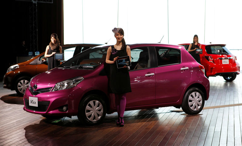 © Reuters. Models pose with Toyota Motor Corp's redesigned compact cars "Vitz" at unveiling in Yokohama
