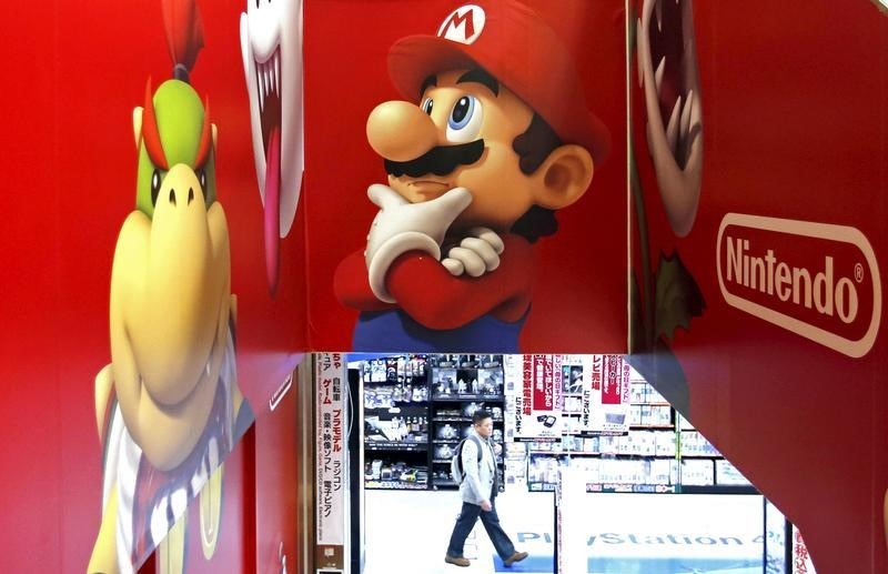 © Reuters. A man walks near Nintendo advertisements at an electronics retail store in Tokyo