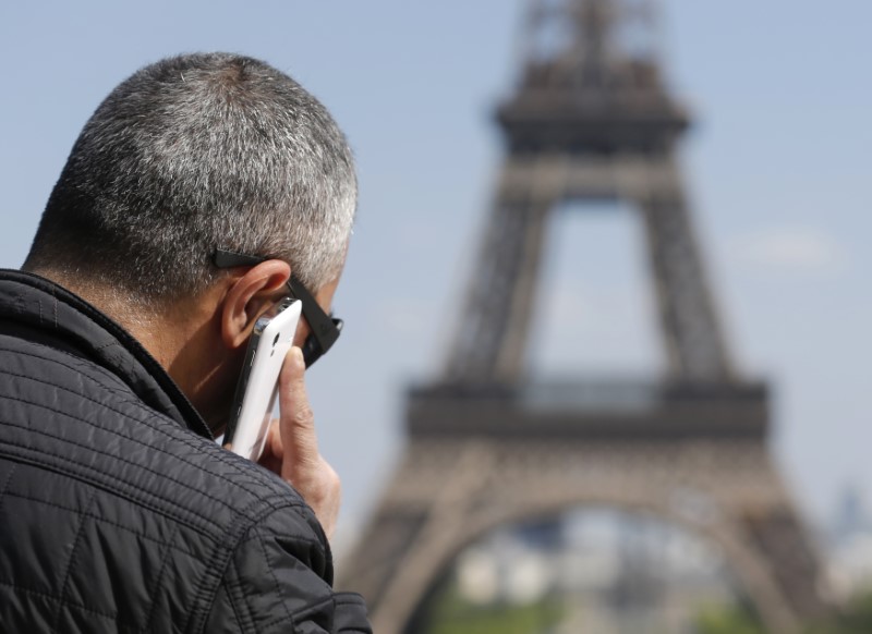 © Reuters. A man makes a phone call using his mobile phone at the Trocadero Square near the Eiffel Tower in Paris