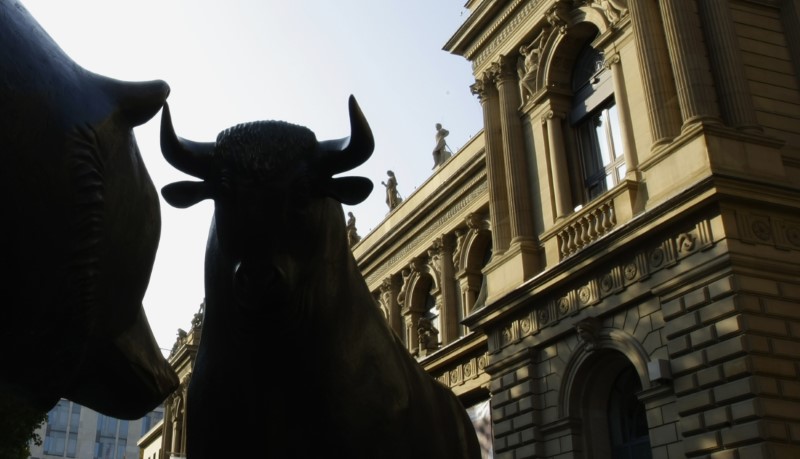 © Reuters. A bull and bear statue are silhouetted in front of the Frankfurt stock exchange