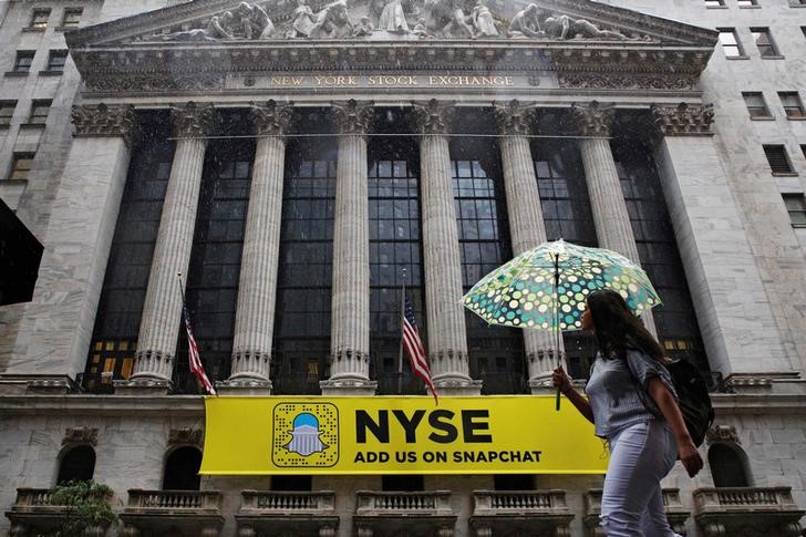 © Reuters. A woman passes by the New York Stock Exchange during the morning commute in New York City