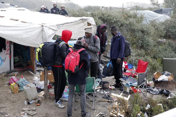 © Reuters. Imigrantes se preparam para deixar acampanhamento em Calais