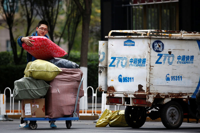 © Reuters. A man unloads parcels from a vehicle of a ZTO Express delivery in Beijing