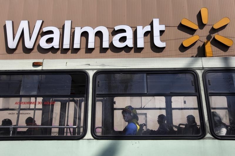 © Reuters. A clown sits inside a bus seen in front of a Wal-Mart store in Mexico City