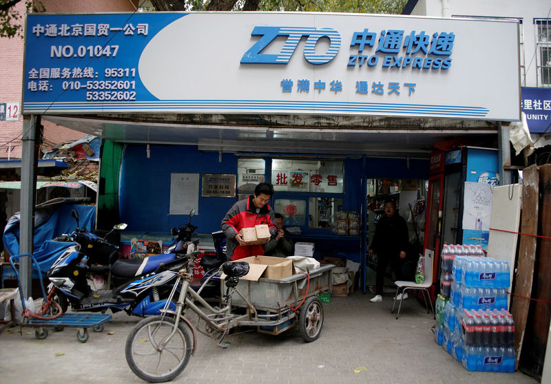 © Reuters. A deliveryman holds parcels at a branch of ZTO Express in Beijing