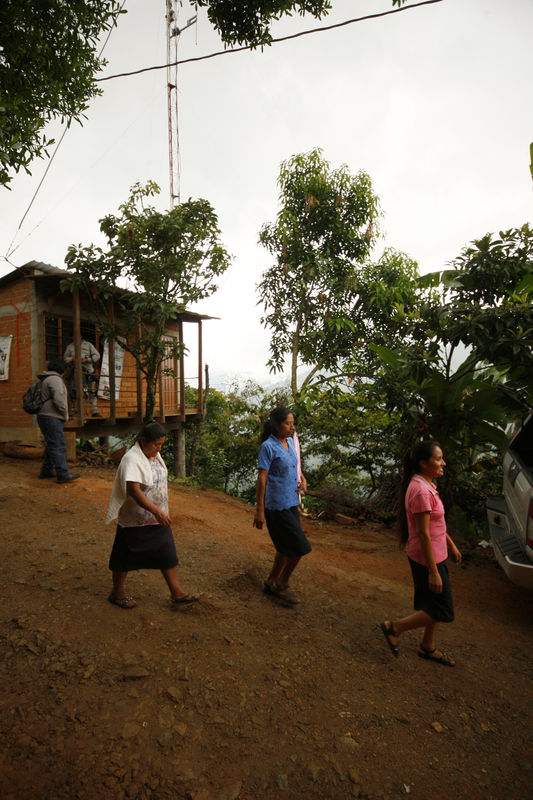 © Reuters. Residents walk past the antenna of the community-run phone network in Santa Maria Yaviche