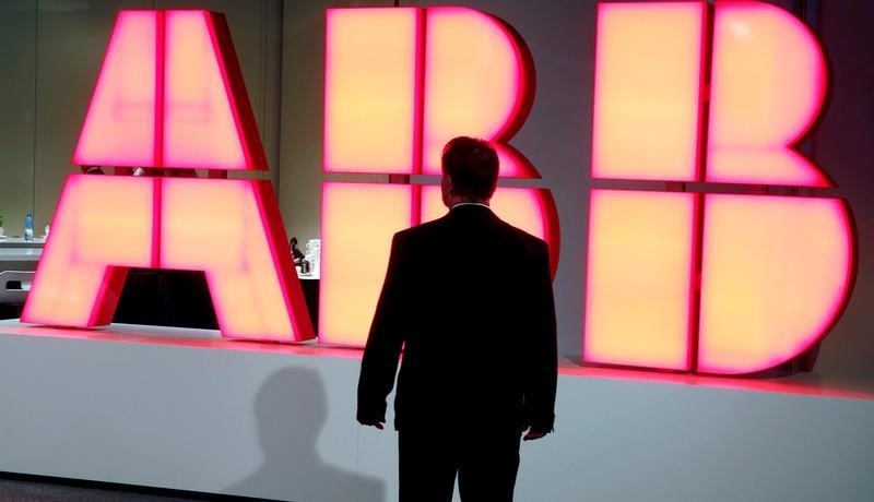 © Reuters. A man stands in front of the logo of Swiss engineering group ABB in Zurich