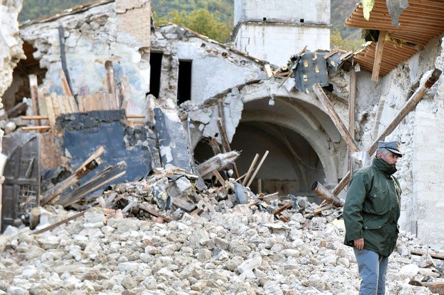 © Reuters. Homem em frente igreja destruída em Campi di Norcia, Itália