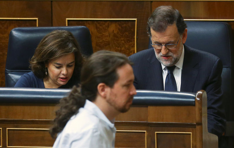 © Reuters. Leader of Podemos party Iglesias walks past Spain's acting PM Rajoy and acting Deputy PM Saenz de Santamaria during the investiture debate at Parliament in Madrid, Spain