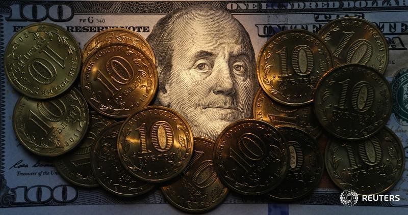 © Reuters. Десятирублевые монеты на стодолларовой купюре