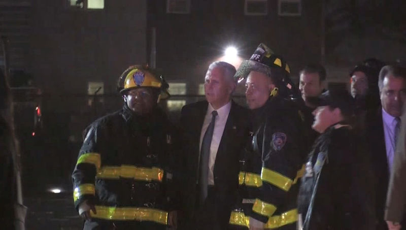 © Reuters. Candidato republicano a vice-presidente dos Estados Unidos, Mike Pence, tira foto com bombeiros após incidente em aeroporto