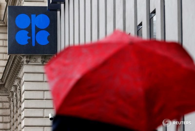 © Reuters. A person carrying an umbrella walks by the OPEC headquarters in Vienna