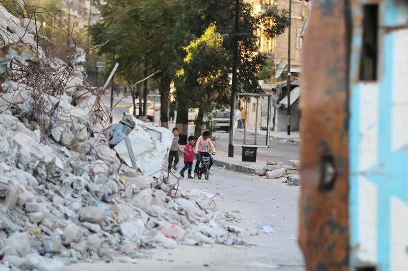 © Reuters. Crianças vistas em meio a destroços na cidade síria de Aleppo