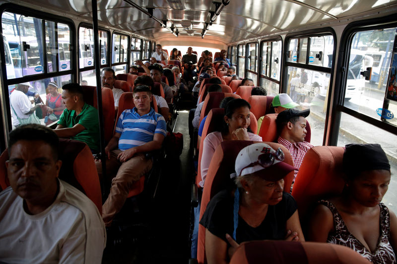 © Reuters. People take a ride on a bus in Caracas