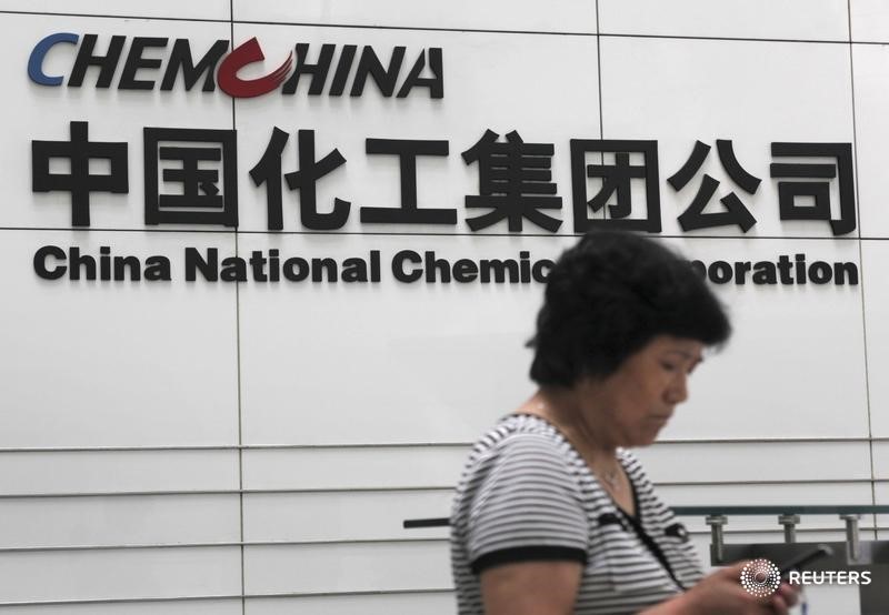 © Reuters. A woman checks her phone at the headquarters of China National Chemical Corporation in Beijing