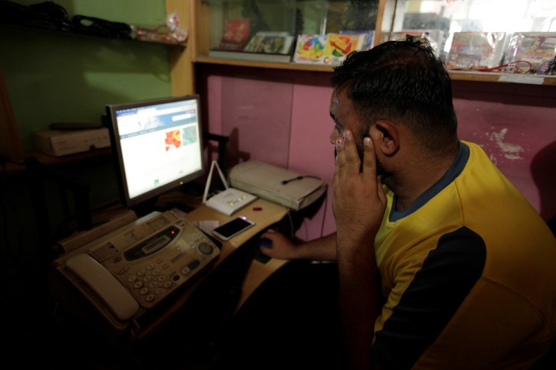 © Reuters. A man explores social media on a computer at an internet club in Islamabad