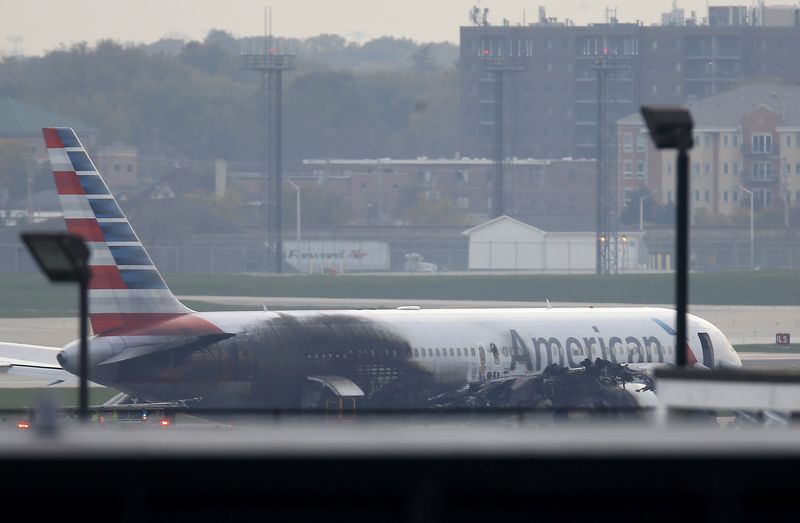 © Reuters. Soot covers the fuselage of an American Airlines jet that blew a tire, sparking a fire and prompting the pilot to abort takeoff before passengers were evacuated from the plane via emergency chute, at O'Hare International Airport in Chicago