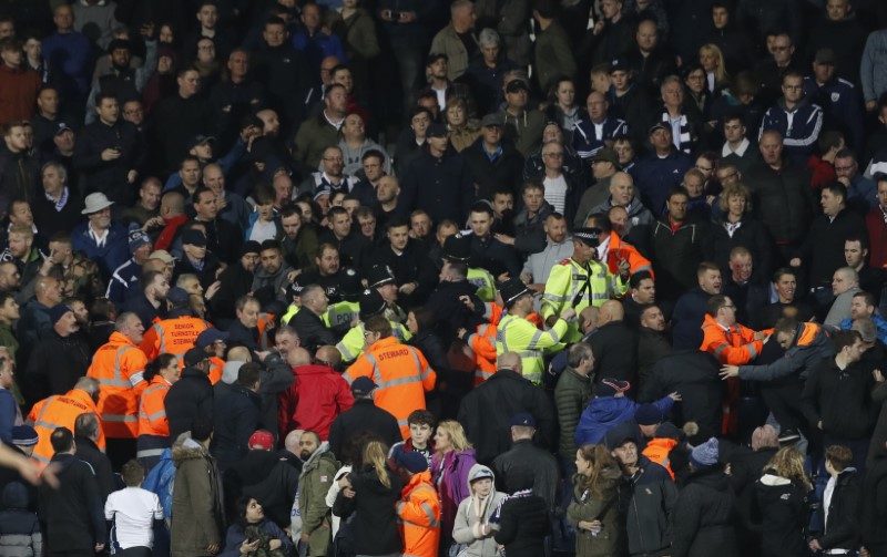 © Reuters. Fans clash during the game