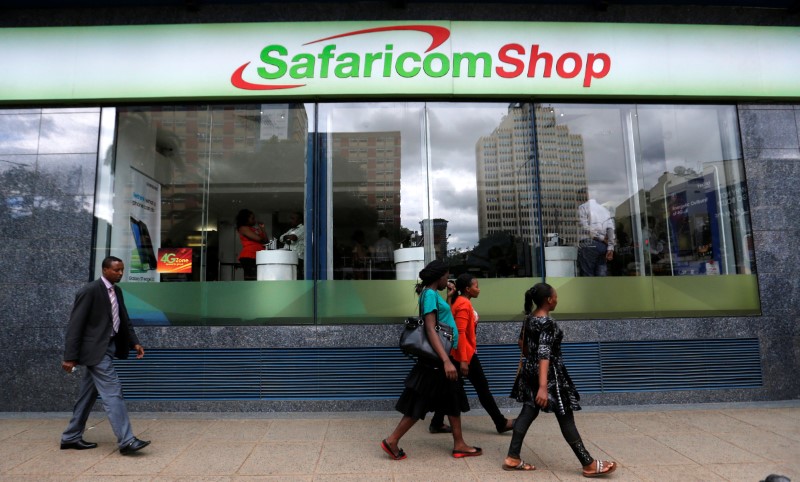 © Reuters. Pedestrians walk past a mobile phone care centre operated by Kenyan's telecom operator Safaricom in the central business district of Kenya's capital Nairobi