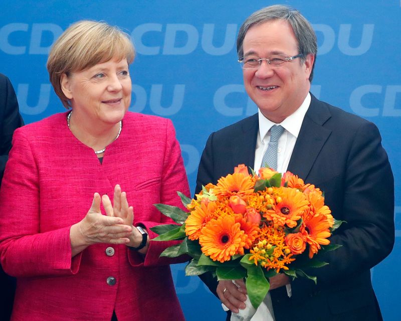 © Reuters. Armin Laschet, top candidate of the CDU receives flowers from German Chancellor Angela Merkel in Berlin