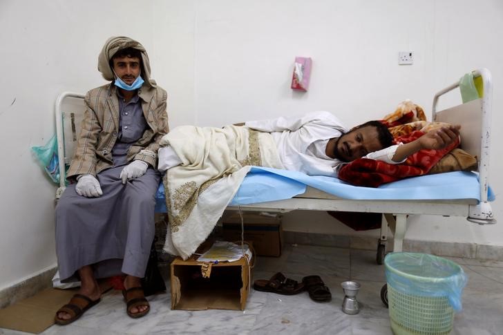 © Reuters. Homem ao lado de familiar com cólera em Sanaa, no Iêmen