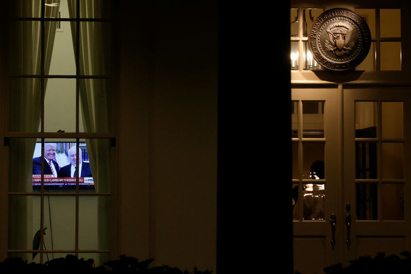 © Reuters. A television plays a news report on U.S. President Donald Trump's recent Oval Office meeting with Russia's Ambassador to the U.S. Sergei Kislyak as night falls on offices and the entrance of the West Wing White House in Washington