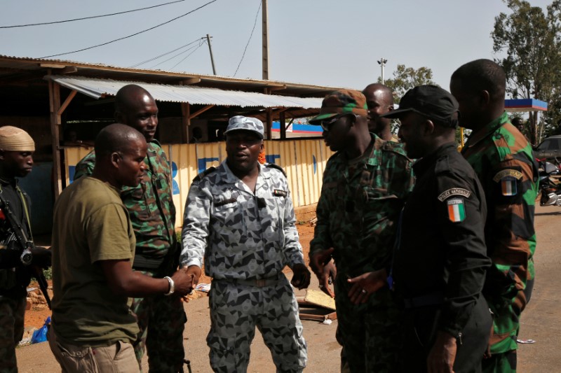 © Reuters. Soldados amotinados apertam as mãos de oficiais da Polícia Nacional da Costa do Marfim, e se preparam para deixar barreira na entrada de Bouake