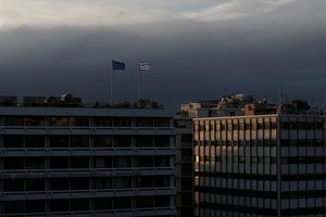 © Reuters. FILE PHOTO: A Greek national flag and a European Union flag flutter atop the Finance Ministry building during sunset in Athens