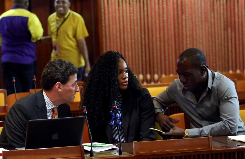 © Reuters. Kaliese Spencer, the reigning Commonwealth Games 400 meters hurdles champion, sits between her attorney Paul Greene and her manager Marvin Anderson, as she attends a meeting with a panel overseeing her anti-doping case in Kingston