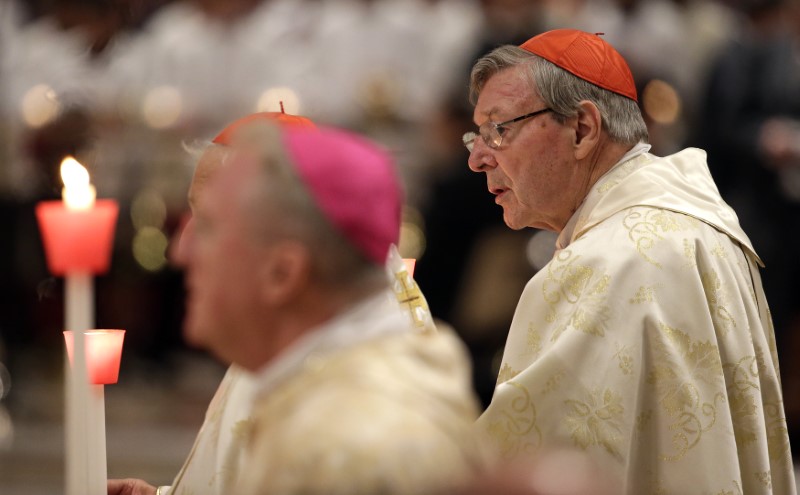 © Reuters. Australian Cardinal George Pell holds a candle as Pope Francis leads the Easter vigil mass in Saint Peter's basilica at the Vatican