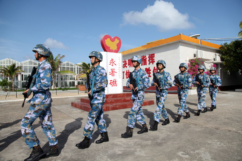 © Reuters. FILE PHOTO: Soldiers of China's People's Liberation Army (PLA) Navy patrol at Fiery Cross Reef, in the Spratly Islands, known in China as the Nansha Islands