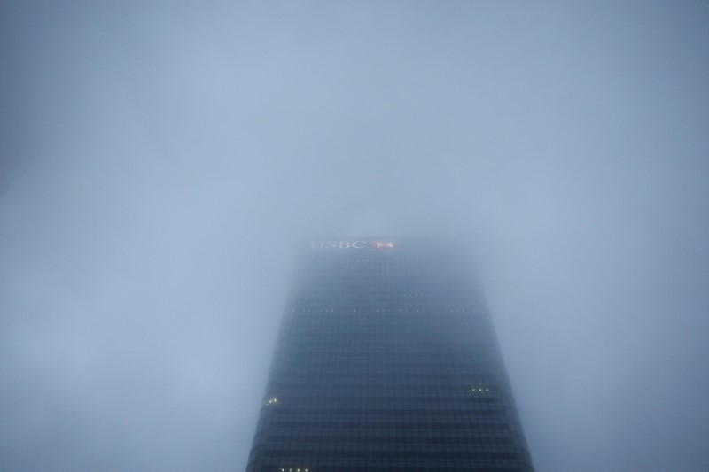 © Reuters. FILE PHOTO: The logo on the building of HSBC's London headquarters appears through the early morning mist in London's Canary Wharf financial district