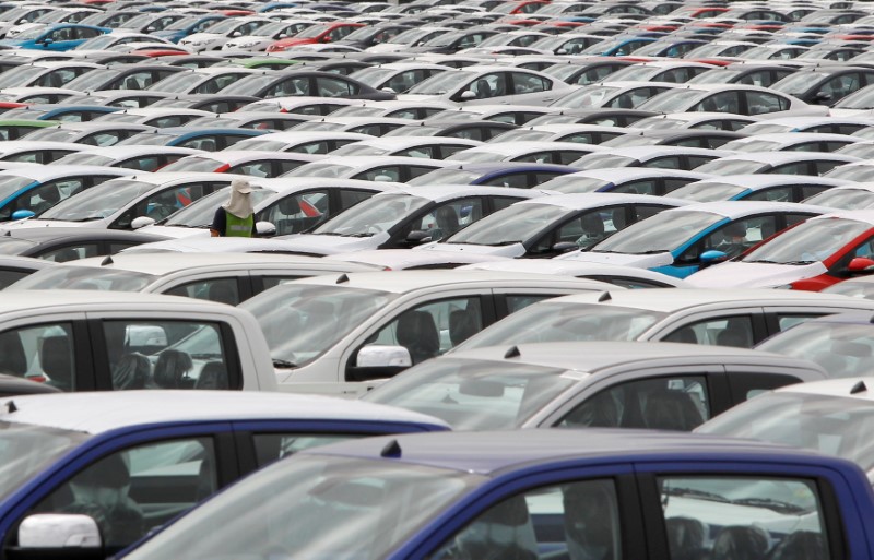 © Reuters. FILE PHOTO - An employee walks among vehicles at AutoAlliance Thailand, a Ford and Mazda joint venture plant, located in Rayong province